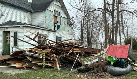 A house stands behind a pile of debris. It's one of many in the Indian Lake area that sustained serious damage after a tornado swept through on March 14.