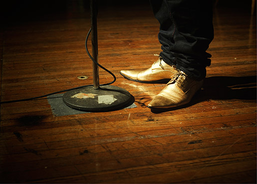 man's shoes next to a mic stand